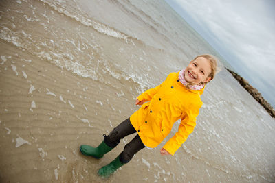 Full length portrait of girl standing at beach