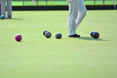 Low section of people playing lawn bowling at playing field