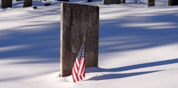 Wooden post on snow covered field