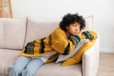 Portrait of smiling woman sitting on sofa at home