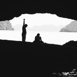 Silhouette of people sitting on mountain