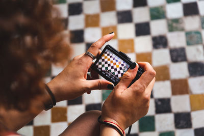 Cropped image of woman photographing tiled floor