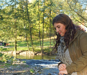 Young woman standing in forest during autumn