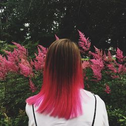 Rear view of woman standing against trees in park