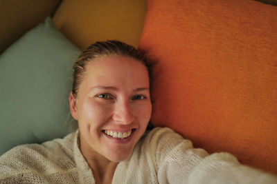 Woman relaxing on the colorful pillows smiling
