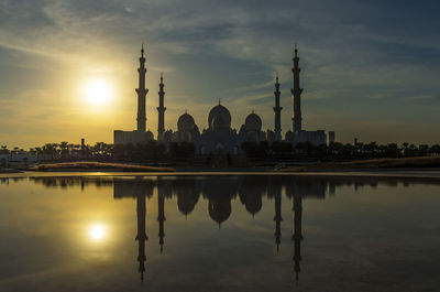 Reflection of buildings in water at sunset