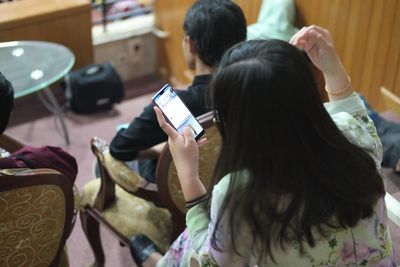 Rear view of woman using mobile phone