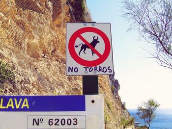 Close-up of road sign against bare trees