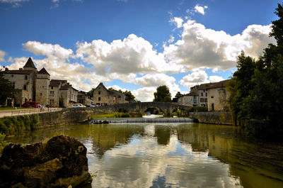 Scenic view of lake by buildings against sky