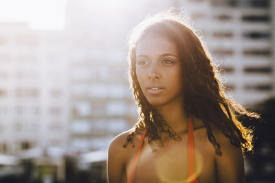 Close-up of young woman looking away during sunset