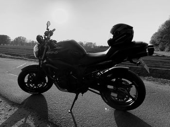 Side view of motorcycle on road against sky