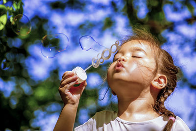 Girl blowing bubbles with bubble wand