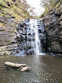Scenic view of waterfall against sky