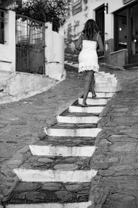 Rear view of woman walking on footpath