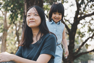 Portrait of happy friends against trees