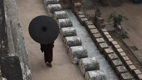 Midsection of woman walking on umbrella