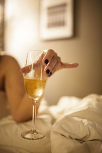 Close-up of champagne glass in bed