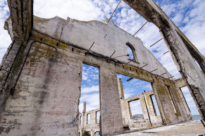 Low angle view of abandoned building against sky