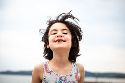 Portrait of smiling girl with dark short hair and thoothless smile