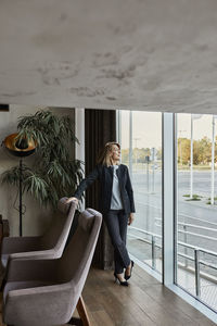 Senior woman looking away while standing in hotel lobby