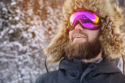Close-up of man wearing glasses looking away during winter