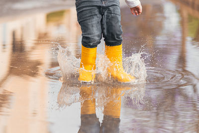 Low section of woman standing in water