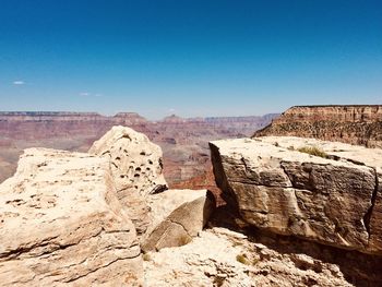 Rock formations on landscape against blue sky