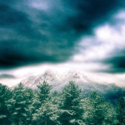 Snow covered mountains against cloudy sky