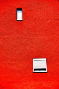 Close-up of windows on red wall