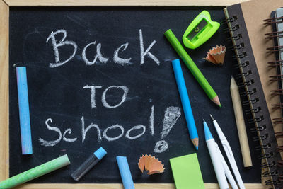 Close-up of back to school text on blackboard with school supplies