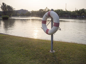 Full length of senior man on lake against sky during sunset