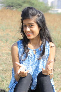 Portrait of smiling young woman sitting outdoors