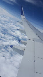 Aerial view of airplane wing over clouds