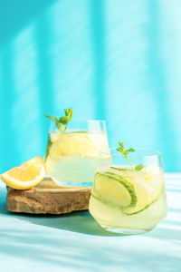 Fresh detox drink with cucumber and lemon slices, with mint in the hard rays of the sun. summer 