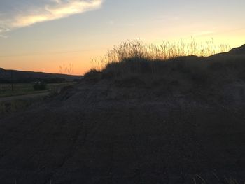 Scenic view of silhouette field against sky during sunset