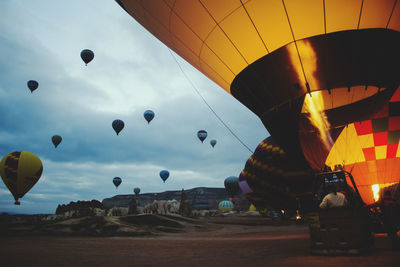 Hot air balloons against cloudy sky at cappadocia