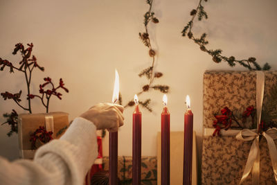 Woman lighting red christmas candles