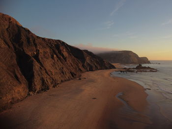 Scenic view of beach against sky during sunset