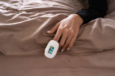 Midsection of person relaxing on bed at home