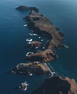 High angle view of rock formation in sea against sky