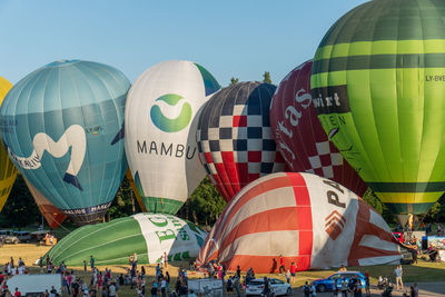 Group of people in front of inflating colorful hot air balloons