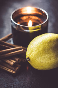 Close-up of cinnamon, lemon and candle