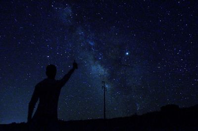 Silhouette man standing in sky at night