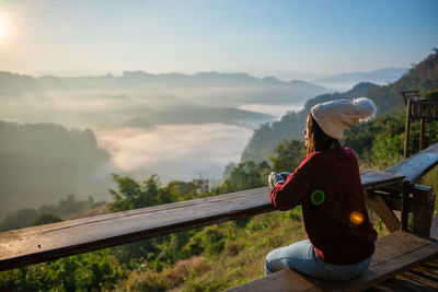 Asian traveler enjoying sunrise on mist mountain. travel in mae hong son ,thailand