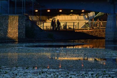 People on illuminated walkway at night