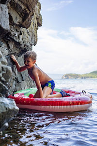 Boy on rock at sea shore