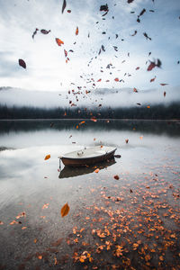 Boat moored in lake against sky