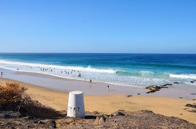 Scenic view of beach against clear blue sky