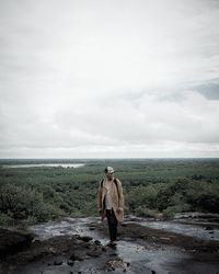 Full length of woman standing on land against sky