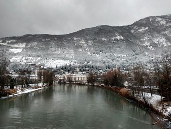 Scenic view of river by mountains against sky